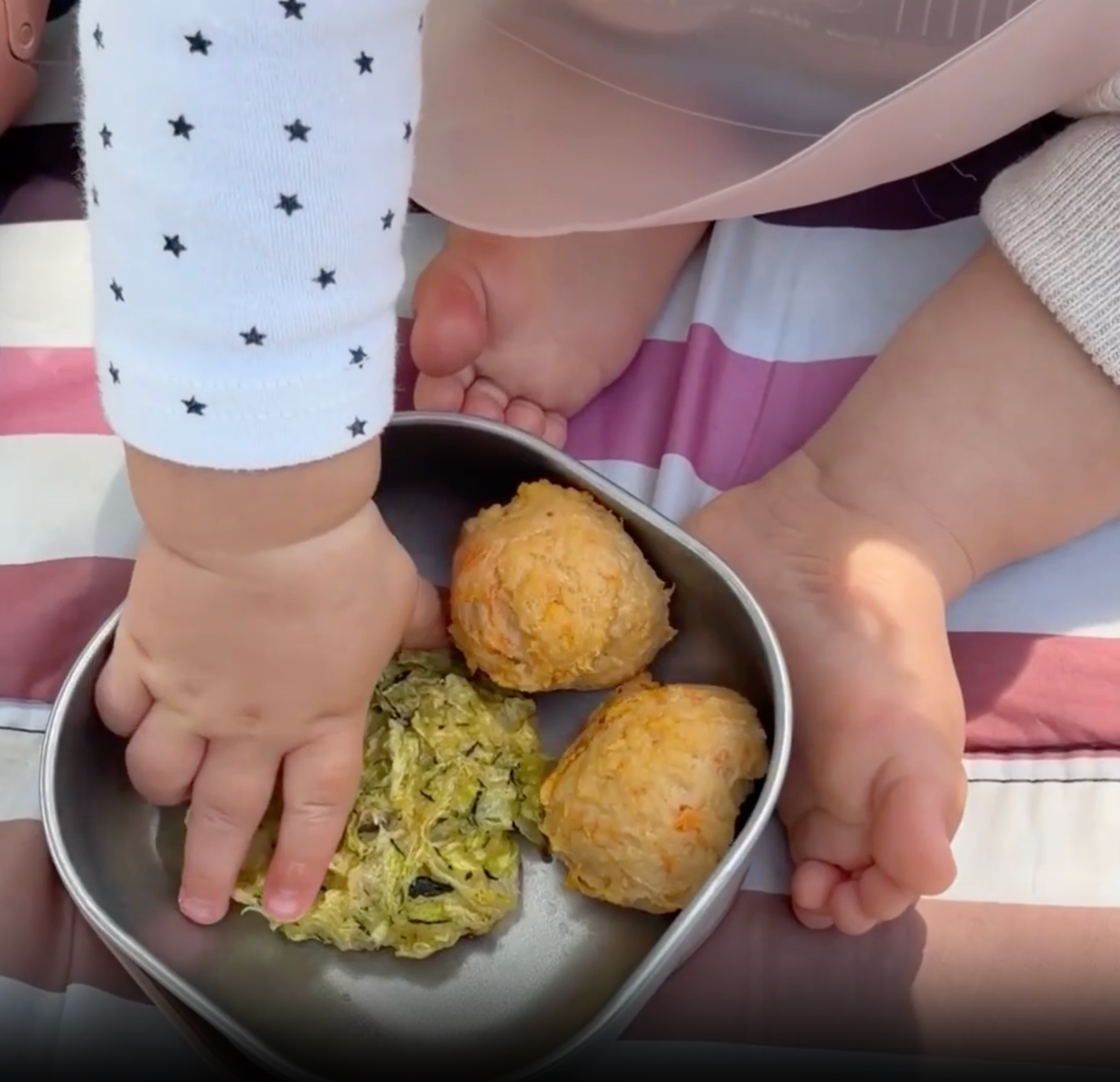 mom and baby having a picnic on the grass eating from beaba stainless steel baby bowls